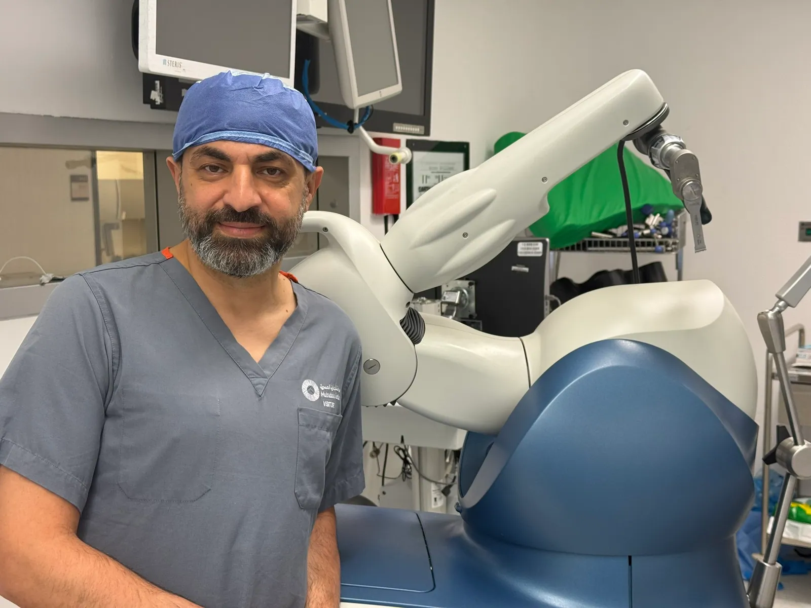 Dr Feras Ya'ish beside the Stryker Mako robotic arm in theatre